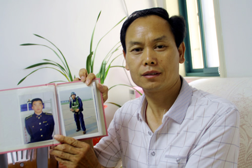 001“参战老兵”鞠振江向记者展示儿子身着戎装的照片。