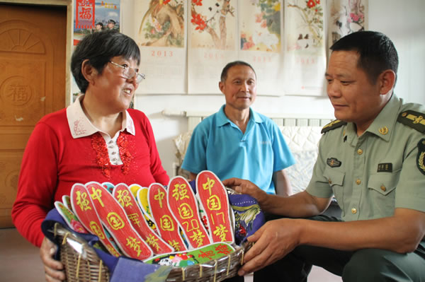 002兵妈妈向专武干部展示自己绣制的拥军鞋垫。
